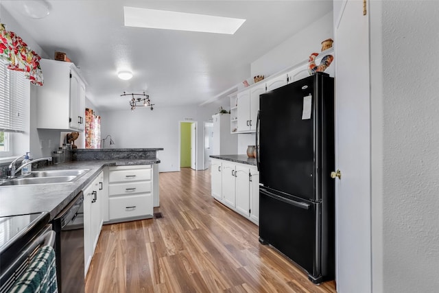 3805 7th St NE Unit 107, Great Falls, MT 59404 - kitchen with black appliances, a skylight, white cabinetry, light wood-type flooring, and a peninsula