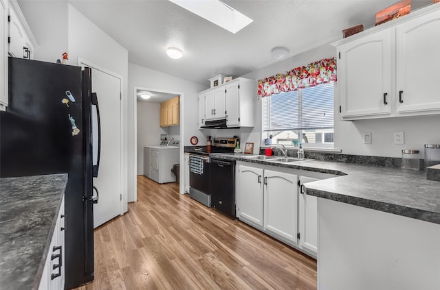 3805 7th St NE Unit 107, Great Falls, MT 59404 - kitchen featuring black appliances, dark countertops, washing machine and clothes dryer, a skylight, and light wood-style flooring