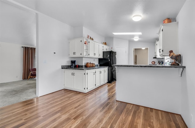 3805 7th St NE Unit 107, Great Falls, MT 59404 - kitchen with freestanding refrigerator, dark countertops, white cabinets, and a peninsula