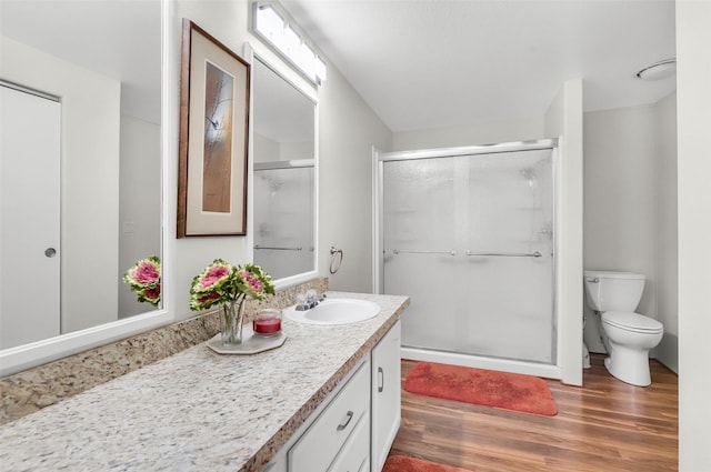 3805 7th St NE Unit 107, Great Falls, MT 59404 - bathroom featuring wood finished floors, a shower stall, vanity, and toilet
