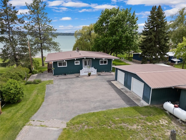 38941 Baypoint Ln, Polson, MT 59860 - view of front of house featuring a detached garage, an outbuilding, a water view, and a front lawn