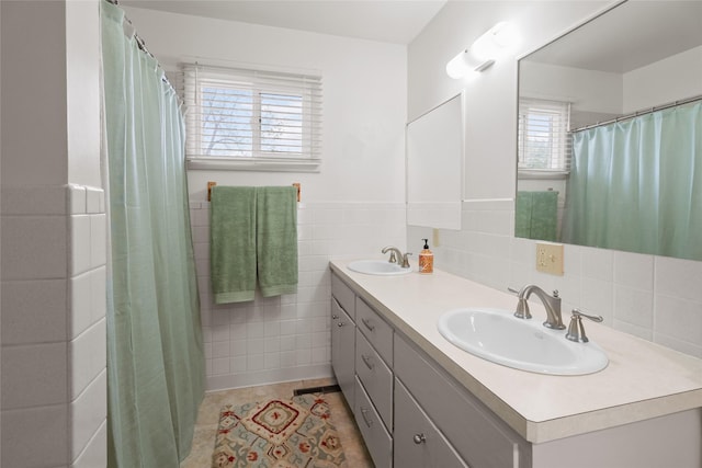 38941 Baypoint Ln, Polson, MT 59860 - full bathroom featuring double vanity, tile walls, tile patterned flooring, a wainscoted wall, and a shower with shower curtain