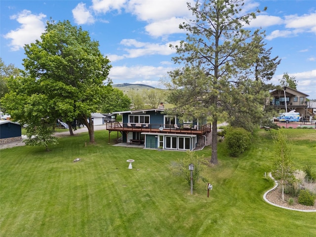 38941 Baypoint Ln, Polson, MT 59860 - rear view of house featuring a deck with mountain view and a lawn