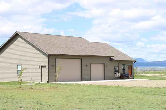 2567 Reardon Rd, Helena, MT 59602 - view of side of home with a mountain view, a yard, roof with shingles, and a garage