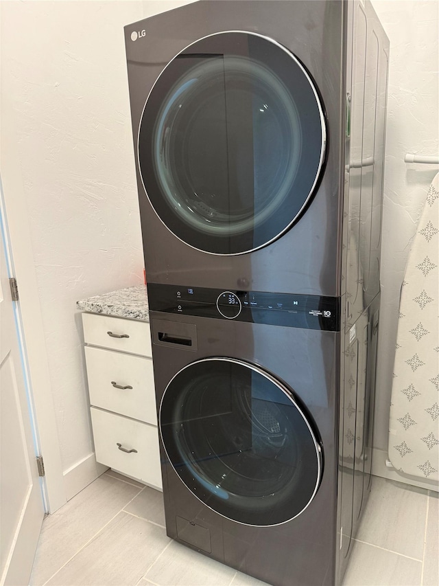 2567 Reardon Rd, Helena, MT 59602 - laundry area with stacked washer / drying machine, light tile patterned flooring, and cabinet space