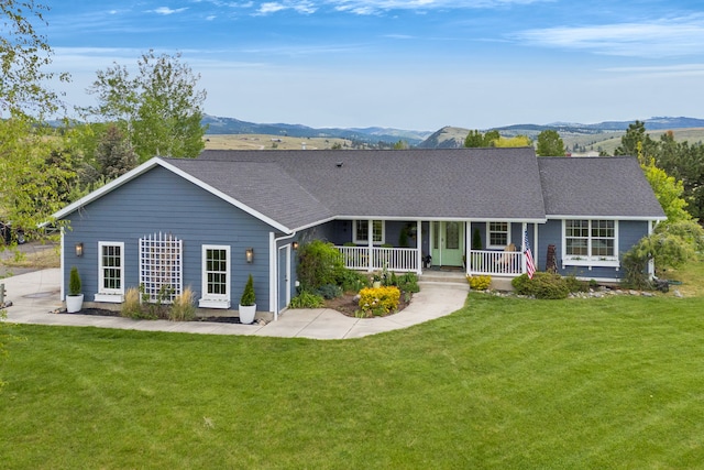 5634 Fairview Ln, Florence, MT 59833 - view of front facade featuring covered porch, a front yard, a mountain view, and a shingled roof