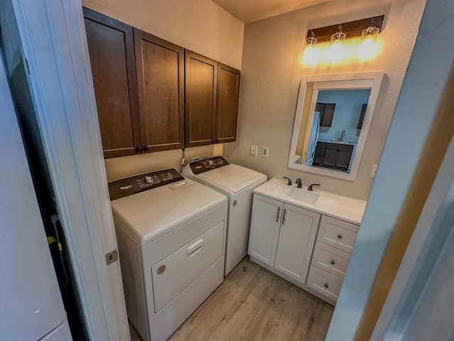 211 W Main St, East Helena, MT 59635 - laundry area featuring washing machine and clothes dryer, cabinet space, light wood finished floors, and a textured wall