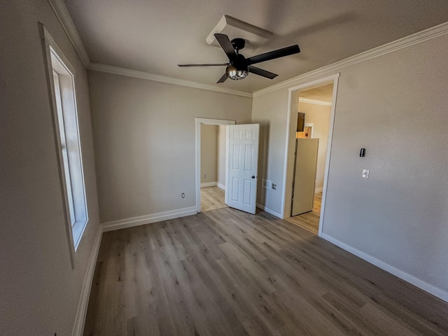 211 W Main St, East Helena, MT 59635 - unfurnished bedroom featuring wood finished floors, baseboards, connected bathroom, a ceiling fan, and crown molding