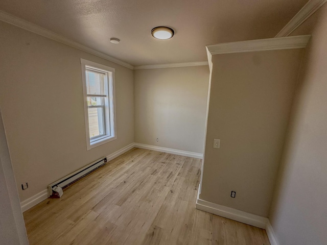 211 W Main St, East Helena, MT 59635 - empty room with baseboard heating, crown molding, light wood-type flooring, and baseboards