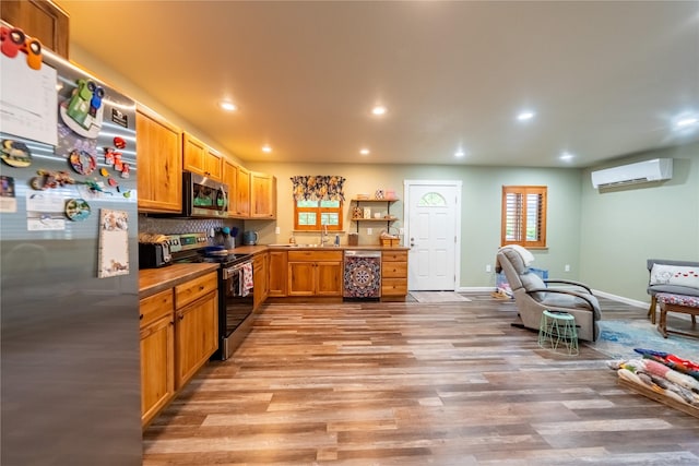 1118 Dakota Ave, Libby, MT 59923 - kitchen with stainless steel appliances, a wall unit AC, light wood-style floors, recessed lighting, and a sink