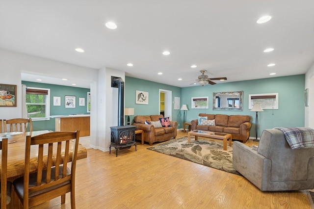 33604 Whitecap Ln, Bigfork, MT 59911 - living room with a wood stove, ceiling fan, light wood-style floors, and recessed lighting