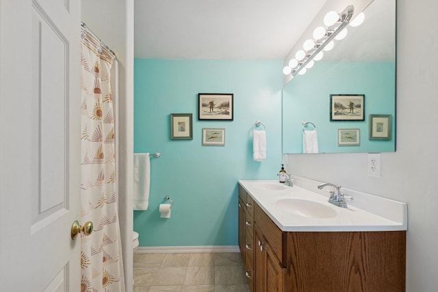 33604 Whitecap Ln, Bigfork, MT 59911 - bathroom featuring double vanity, baseboards, and toilet