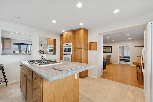 33604 Whitecap Ln, Bigfork, MT 59911 - kitchen featuring white appliances, recessed lighting, a center island, baseboards, and light stone countertops