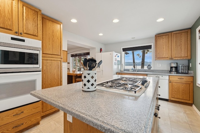 33604 Whitecap Ln, Bigfork, MT 59911 - kitchen with white appliances, a sink, a center island, recessed lighting, and light countertops