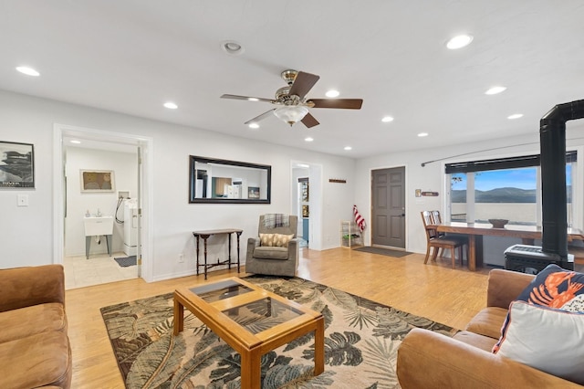 33604 Whitecap Ln, Bigfork, MT 59911 - living area with a wood stove, ceiling fan, recessed lighting, and light wood finished floors