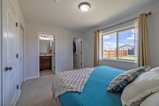 850 Pollux Rd, Helena, MT 59602 - bedroom with a closet, light carpet, baseboards, connected bathroom, and a sink