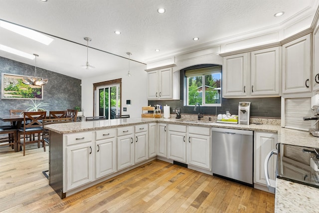 4884 Lower Miller Creek Rd, Missoula, MT 59803 - kitchen featuring stainless steel dishwasher, a peninsula, plenty of natural light, light wood-style flooring, and recessed lighting