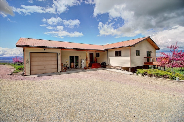 31521 Mcdonald Lake Rd, Saint Ignatius, MT 59865 - view of front of home featuring an attached garage, gravel driveway, and metal roof
