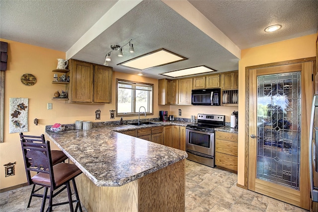 31521 Mcdonald Lake Rd, Saint Ignatius, MT 59865 - kitchen featuring stainless steel electric range, black microwave, a sink, a peninsula, and a textured ceiling