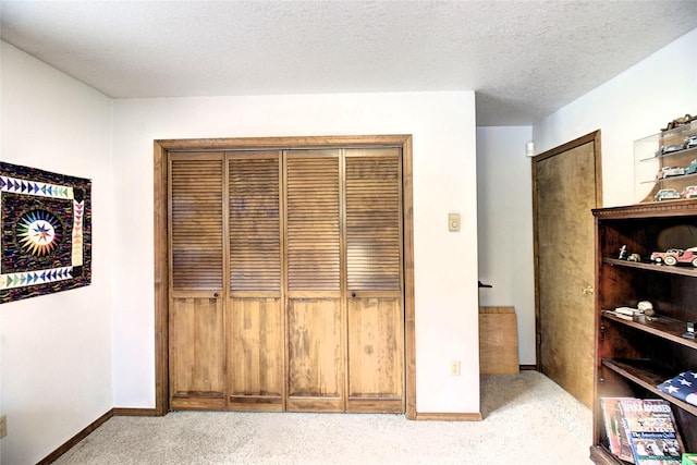 31521 Mcdonald Lake Rd, Saint Ignatius, MT 59865 - unfurnished bedroom featuring carpet flooring, baseboards, a closet, and a textured ceiling
