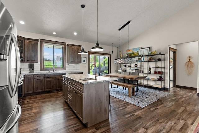 219 Rudys Way, Hamilton, MT 59840 - kitchen with a sink, freestanding refrigerator, dark wood-style floors, a center island with sink, and lofted ceiling
