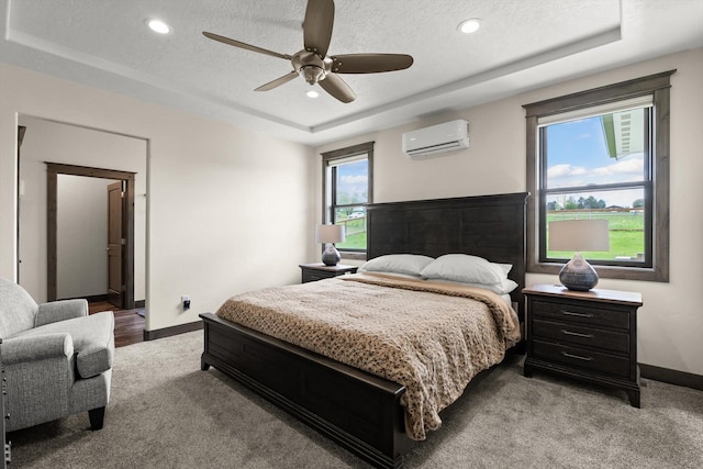 219 Rudys Way, Hamilton, MT 59840 - bedroom with an AC wall unit, a raised ceiling, carpet flooring, baseboards, and a textured ceiling