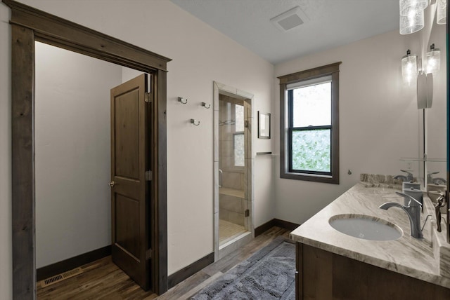 219 Rudys Way, Hamilton, MT 59840 - full bathroom featuring wood finished floors, a shower stall, baseboards, and double vanity