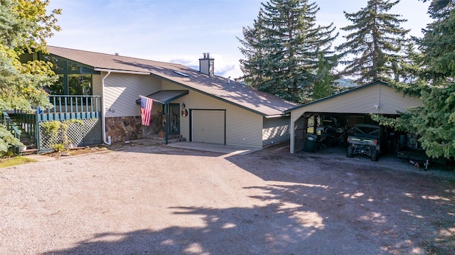 280 Hartt Hill Dr, Kalispell, MT 59901 - ranch-style house featuring driveway, a chimney, a garage, stone siding, and a carport