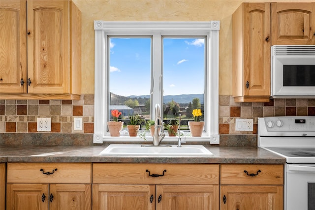 280 Hartt Hill Dr, Kalispell, MT 59901 - kitchen with white appliances, a sink, a mountain view, dark countertops, and decorative backsplash