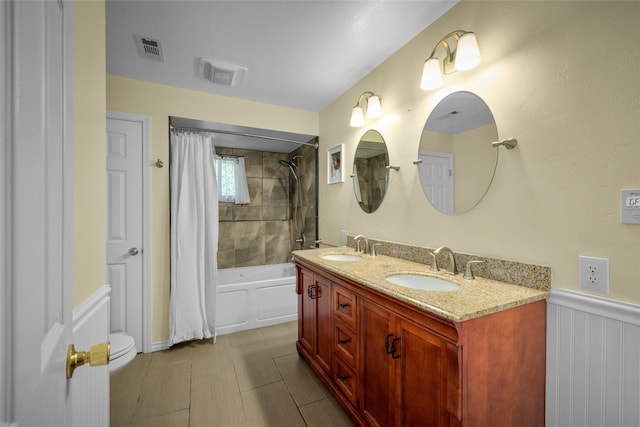 280 Hartt Hill Dr, Kalispell, MT 59901 - full bath with shower / bath combo with shower curtain, double vanity, a wainscoted wall, and toilet