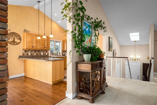 280 Hartt Hill Dr, Kalispell, MT 59901 - bar area with a skylight, a chandelier, high vaulted ceiling, wood finished floors, and pendant lighting