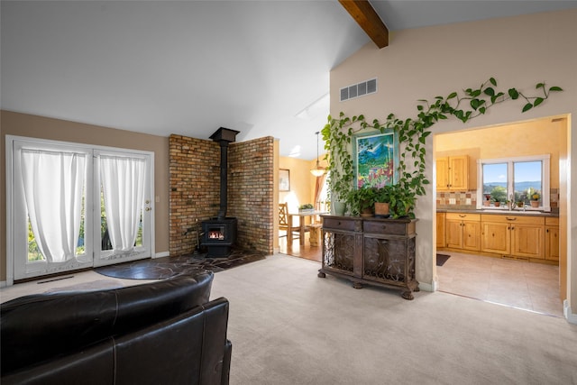 280 Hartt Hill Dr, Kalispell, MT 59901 - living area featuring a wood stove, healthy amount of natural light, light colored carpet, and light tile patterned floors