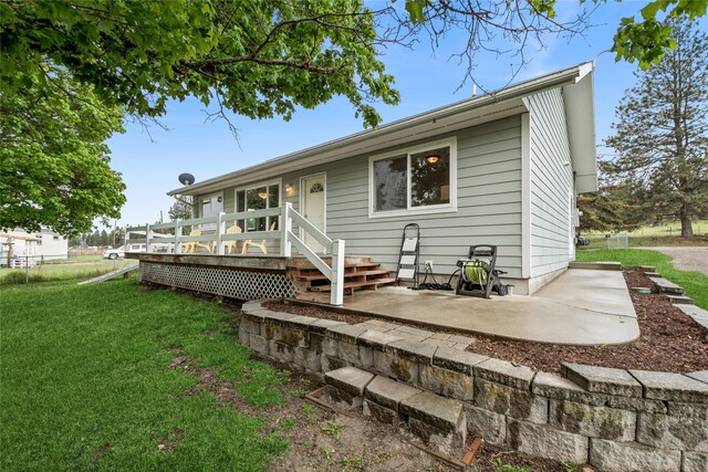 175 Caps Rd, Kalispell, MT 59901 - rear view of house with a lawn, a deck, and a patio