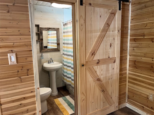 14367 US Highway 2 E, Essex, MT 59916 - bathroom featuring toilet, wood finished floors, curtained shower, and a sink