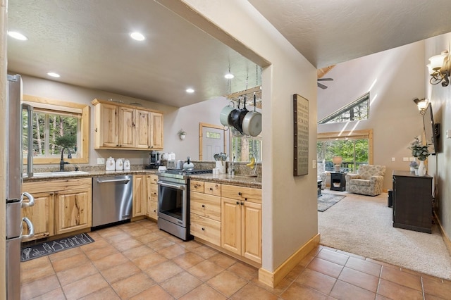 14132 Pine St, Bigfork, MT 59911 - kitchen with appliances with stainless steel finishes, light brown cabinets, a sink, light colored carpet, and recessed lighting