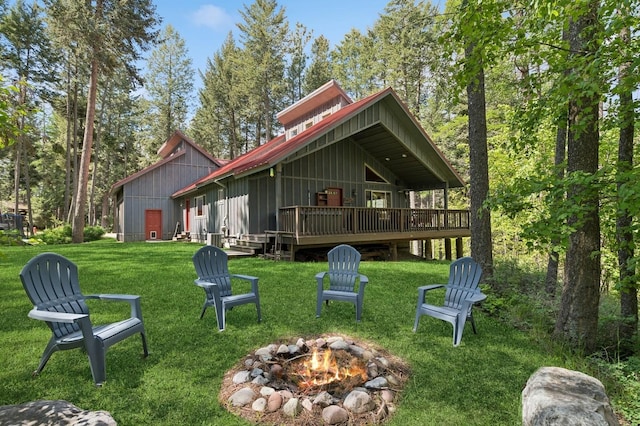 14132 Pine St, Bigfork, MT 59911 - back of property featuring an outdoor fire pit, a deck, board and batten siding, and a yard