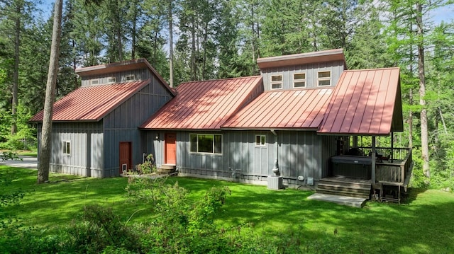 14132 Pine St, Bigfork, MT 59911 - rear view of house featuring a standing seam roof, metal roof, a lawn, and entry steps