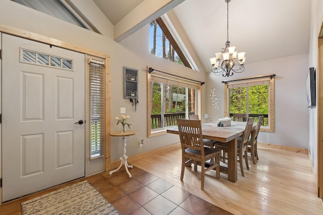 14132 Pine St, Bigfork, MT 59911 - dining area featuring a chandelier, baseboards, beamed ceiling, light wood-type flooring, and high vaulted ceiling