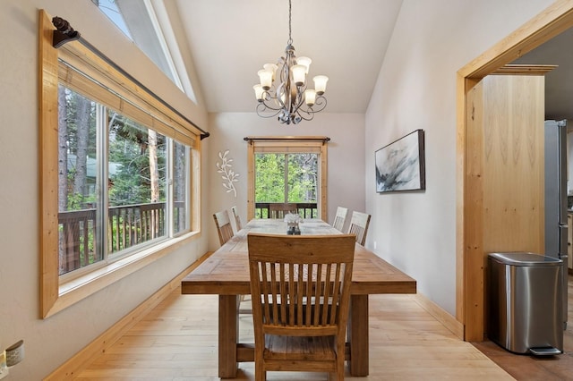 14132 Pine St, Bigfork, MT 59911 - dining space with a chandelier, light wood finished floors, lofted ceiling, and baseboards
