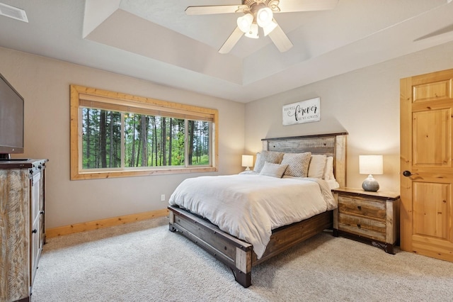 14132 Pine St, Bigfork, MT 59911 - bedroom featuring a tray ceiling, light carpet, baseboards, and ceiling fan
