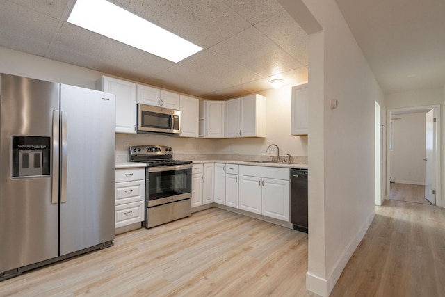 1624 Cannon St Unit 26, Helena, MT 59601 - kitchen with stainless steel appliances, a sink, a paneled ceiling, light wood-type flooring, and light countertops