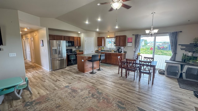 3319 Ivy Dr, Helena, MT 59602 - kitchen with black appliances, lofted ceiling, light wood-style floors, ceiling fan, and a breakfast bar area