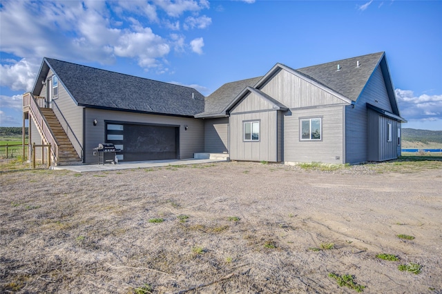 4731 Sea Ray Rd, Helena, MT 59602 - view of front facade with stairs, a shingled roof, a garage, and driveway