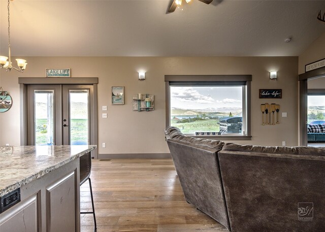 4731 Sea Ray Rd, Helena, MT 59602 - living room with light wood-type flooring, a ceiling fan, a chandelier, and baseboards