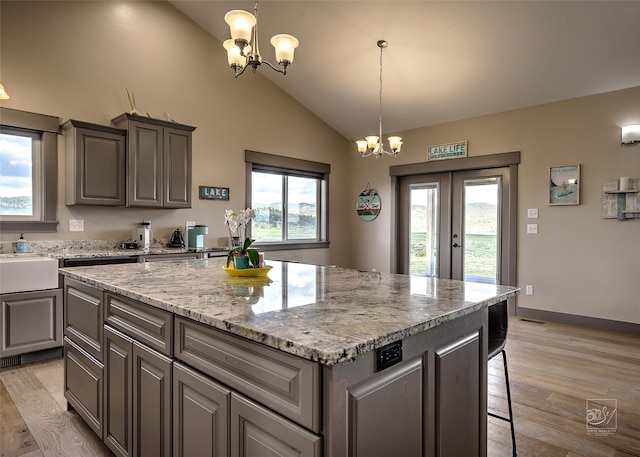 4731 Sea Ray Rd, Helena, MT 59602 - kitchen with a chandelier, vaulted ceiling, french doors, a kitchen island, and light wood-type flooring