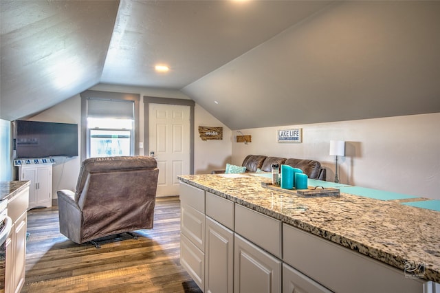 4731 Sea Ray Rd, Helena, MT 59602 - kitchen featuring dark wood-style floors, lofted ceiling, light stone counters, open floor plan, and white cabinets