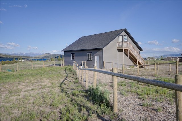 4731 Sea Ray Rd, Helena, MT 59602 - view of outdoor structure featuring stairs, a fenced backyard, a mountain view, and a view of rural / pastoral area