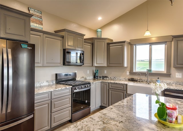 4731 Sea Ray Rd, Helena, MT 59602 - kitchen with appliances with stainless steel finishes, gray cabinetry, vaulted ceiling, light stone counters, and hanging light fixtures