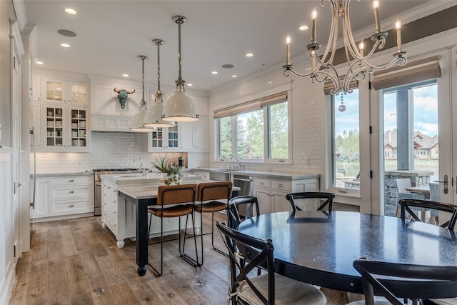3070 River Lakes Dr, Whitefish, MT 59937 - kitchen with white cabinetry, a kitchen island with sink, high end stainless steel range, decorative backsplash, and wood finished floors