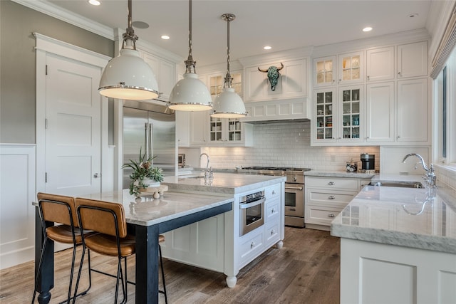 3070 River Lakes Dr, Whitefish, MT 59937 - kitchen with a sink, high end appliances, white cabinets, crown molding, and backsplash